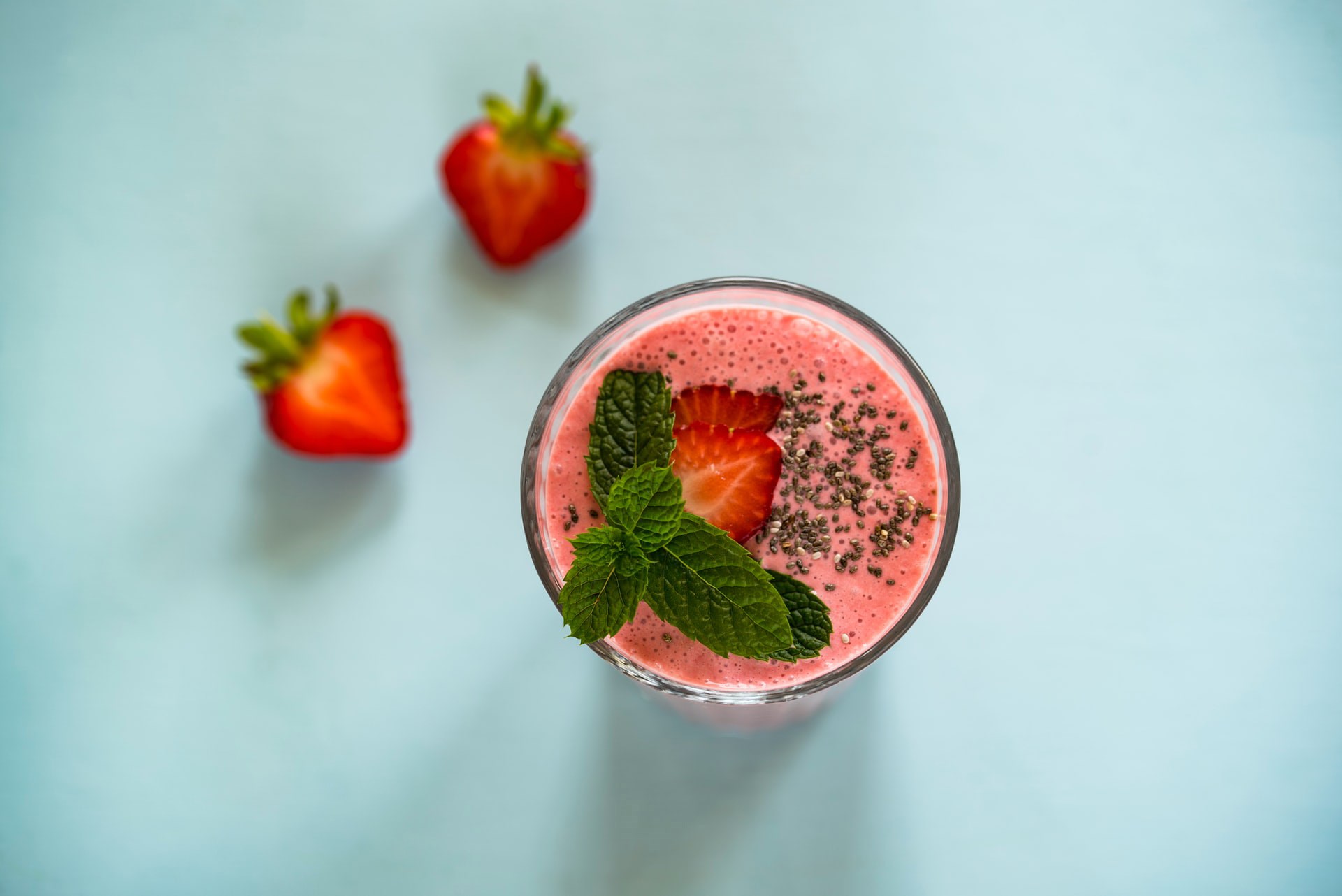Ett glas med smoothie och jordgubbar 