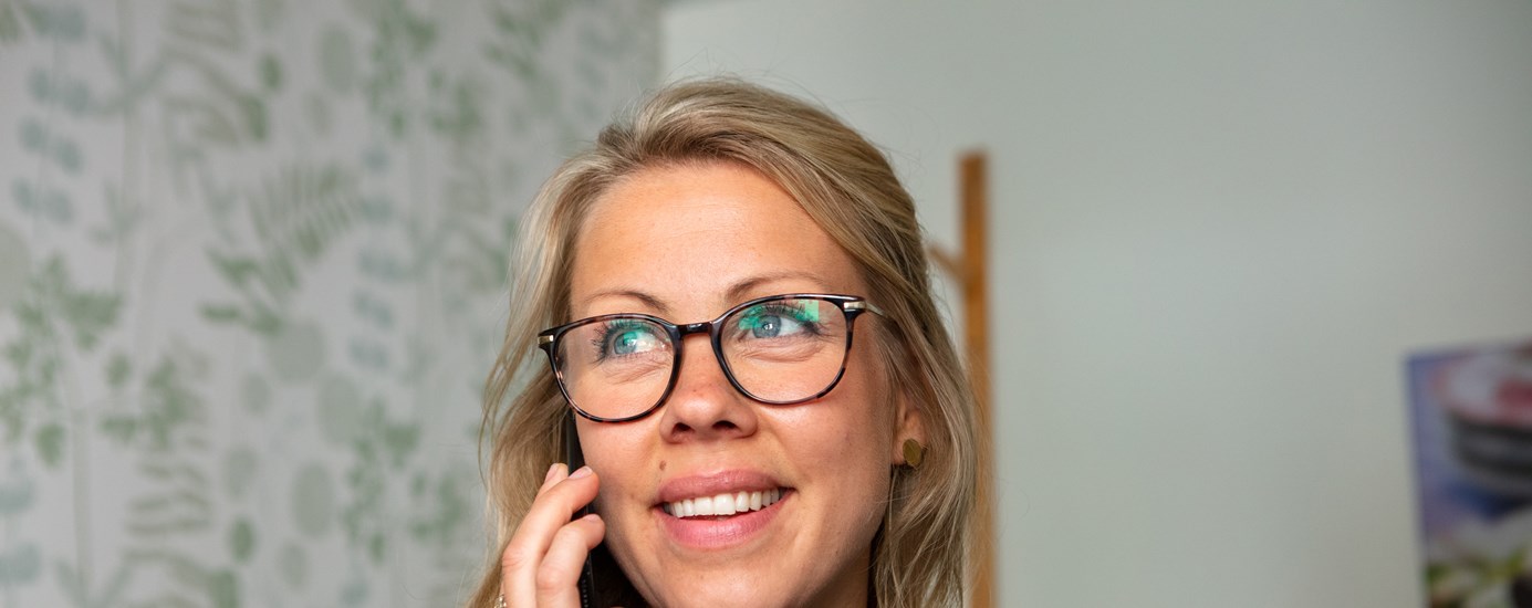 En kvinna som bär glasögon och ler mot kameran 